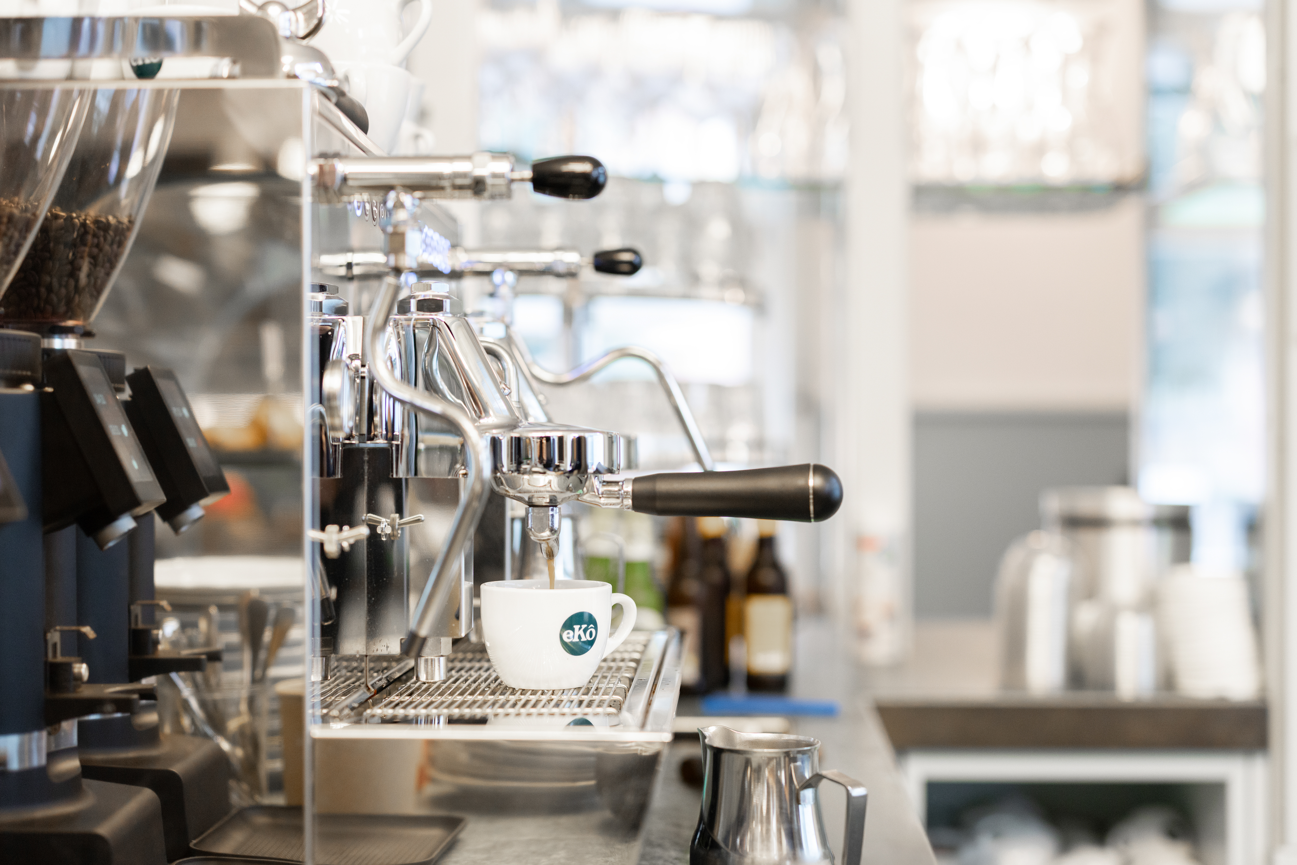 Eine Industriekaffeemaschine von der Seite, es läuft Kaffee in eine Tasse