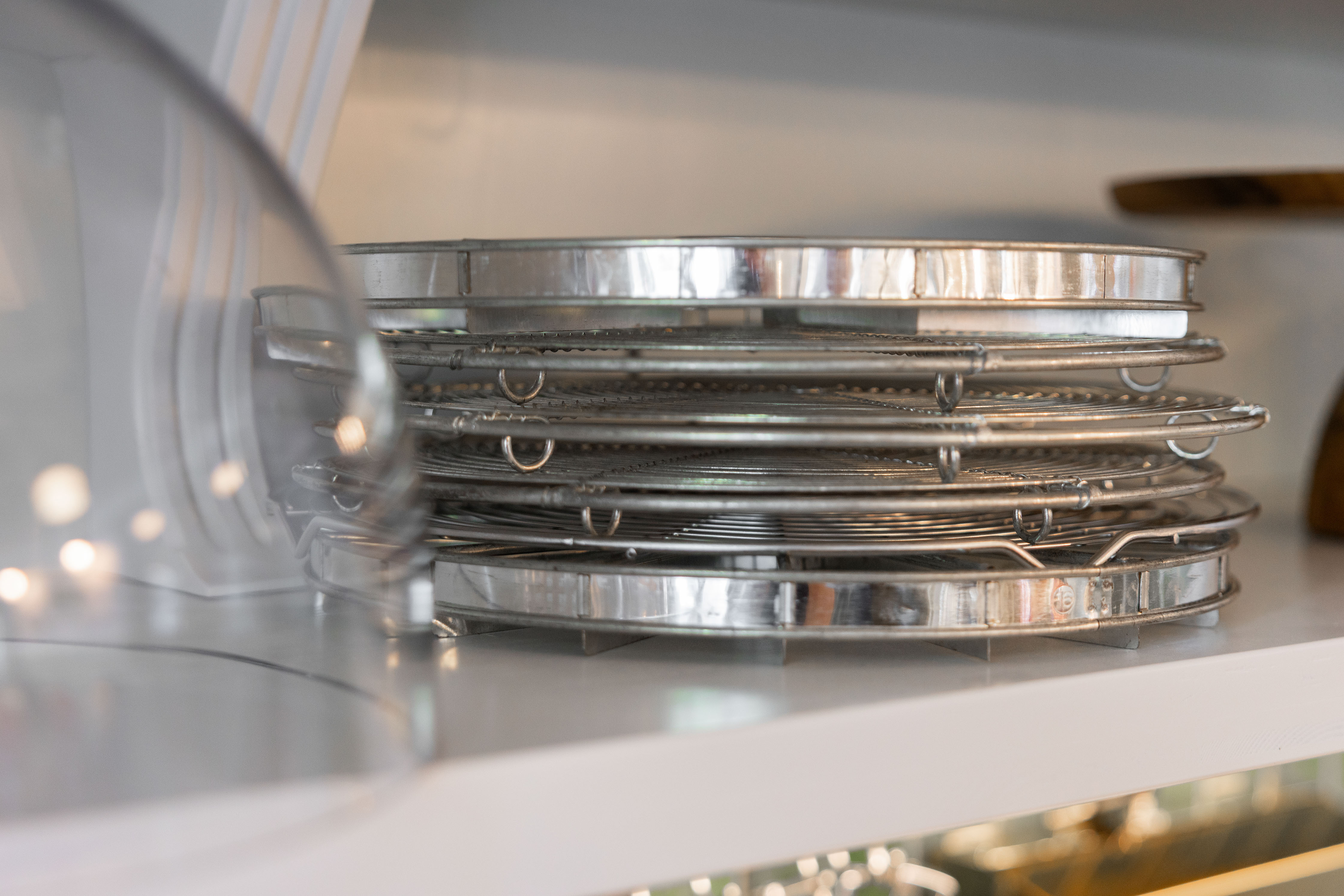 Ein Stapel Kühlgitter für heisse Backwaren auf einem Regalbrett, Nahaufnahme