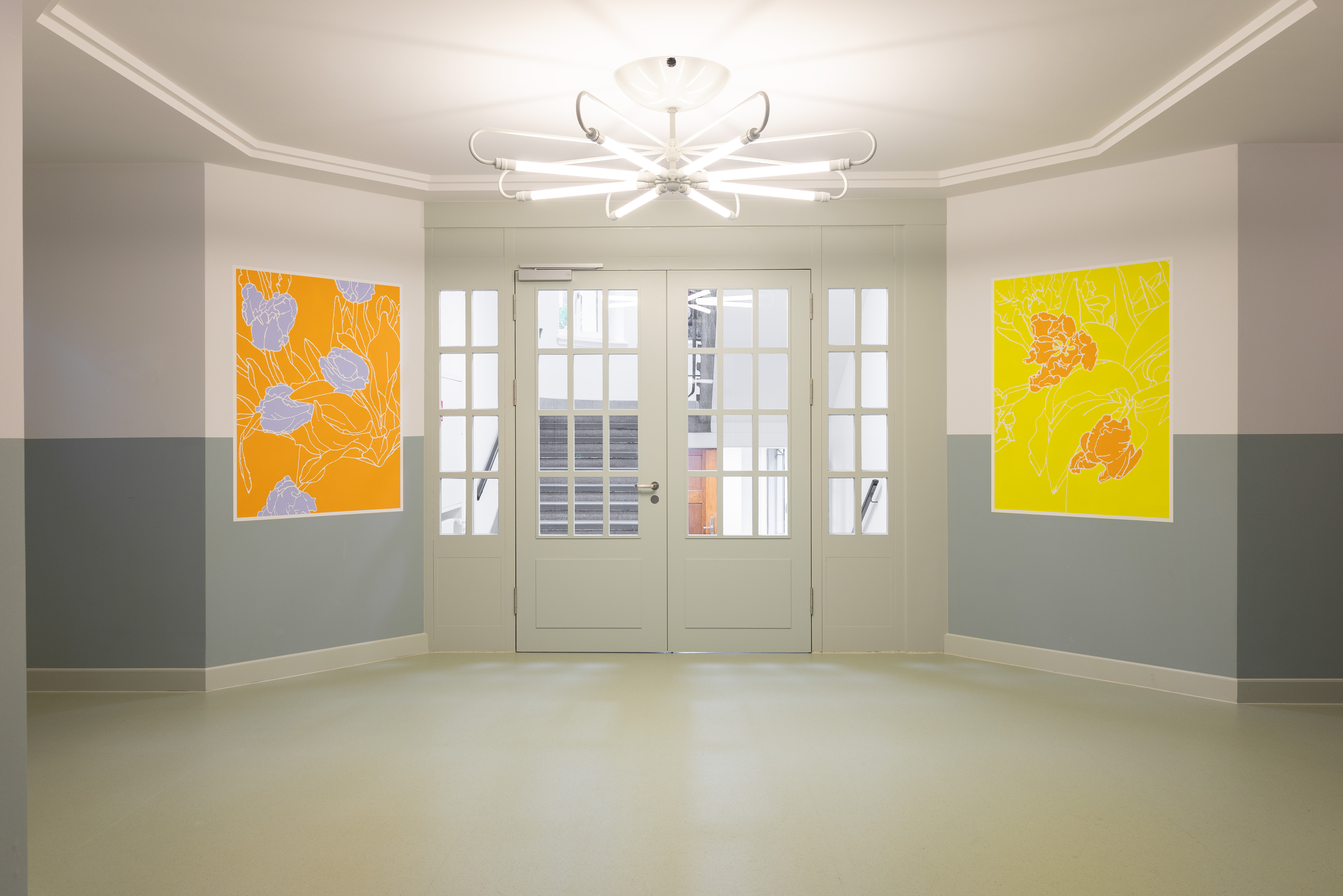 Eingangsbereich mit Tür, prägnanter Kronleuchter, zwei Bilder in Orange- und Gelbtönen, Foyer